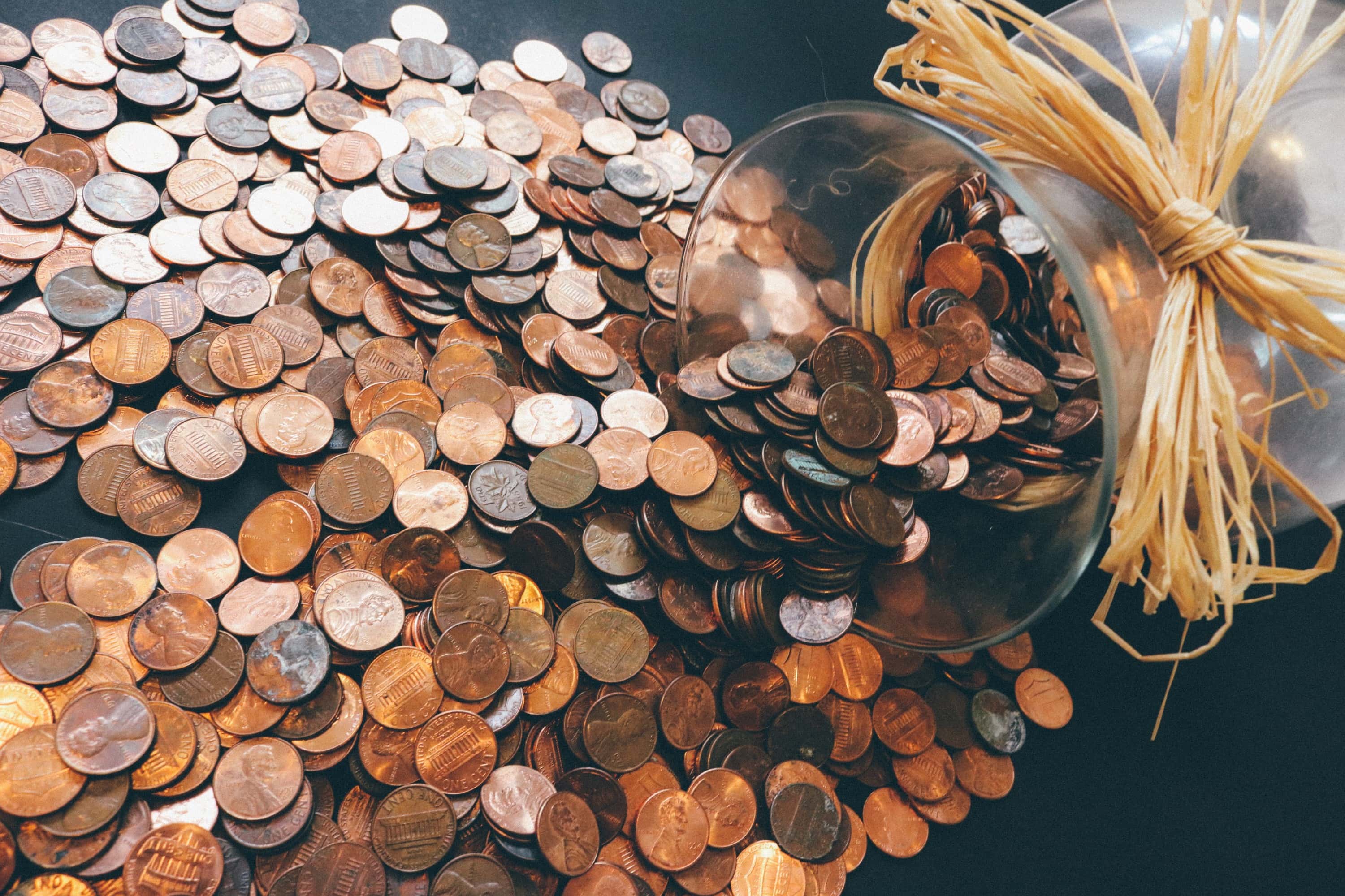 Large jar of copper coins tipped over with all the coins pouring out