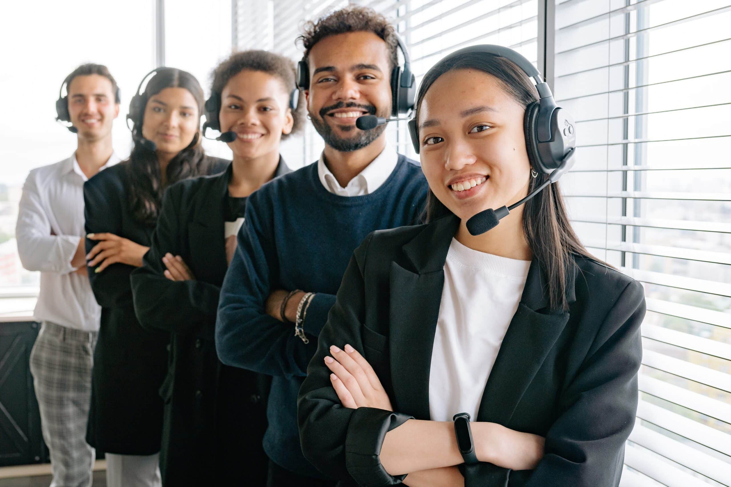 5 Customer Service people standing in a row with headsets on