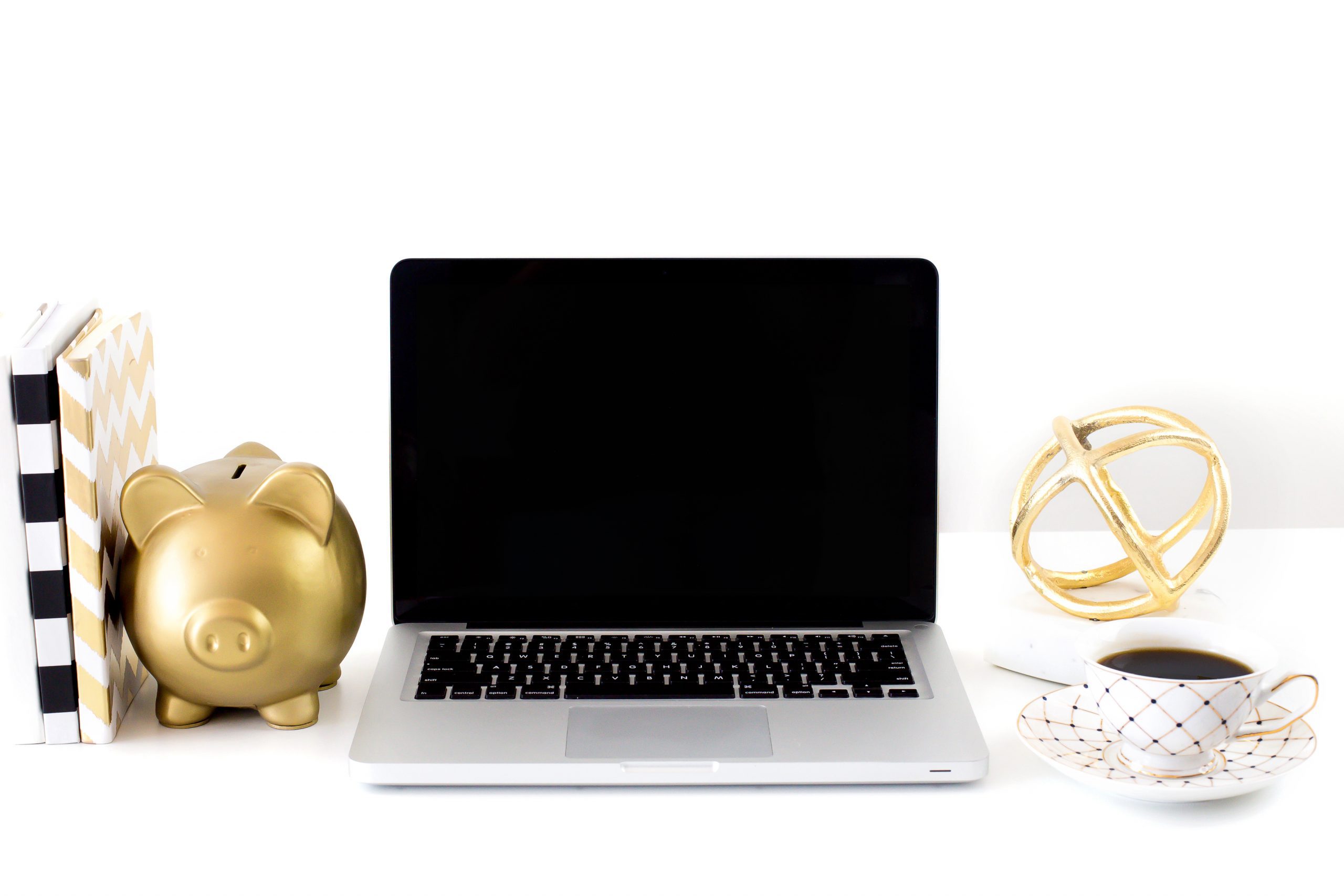 Piggy bank next to a laptop computer