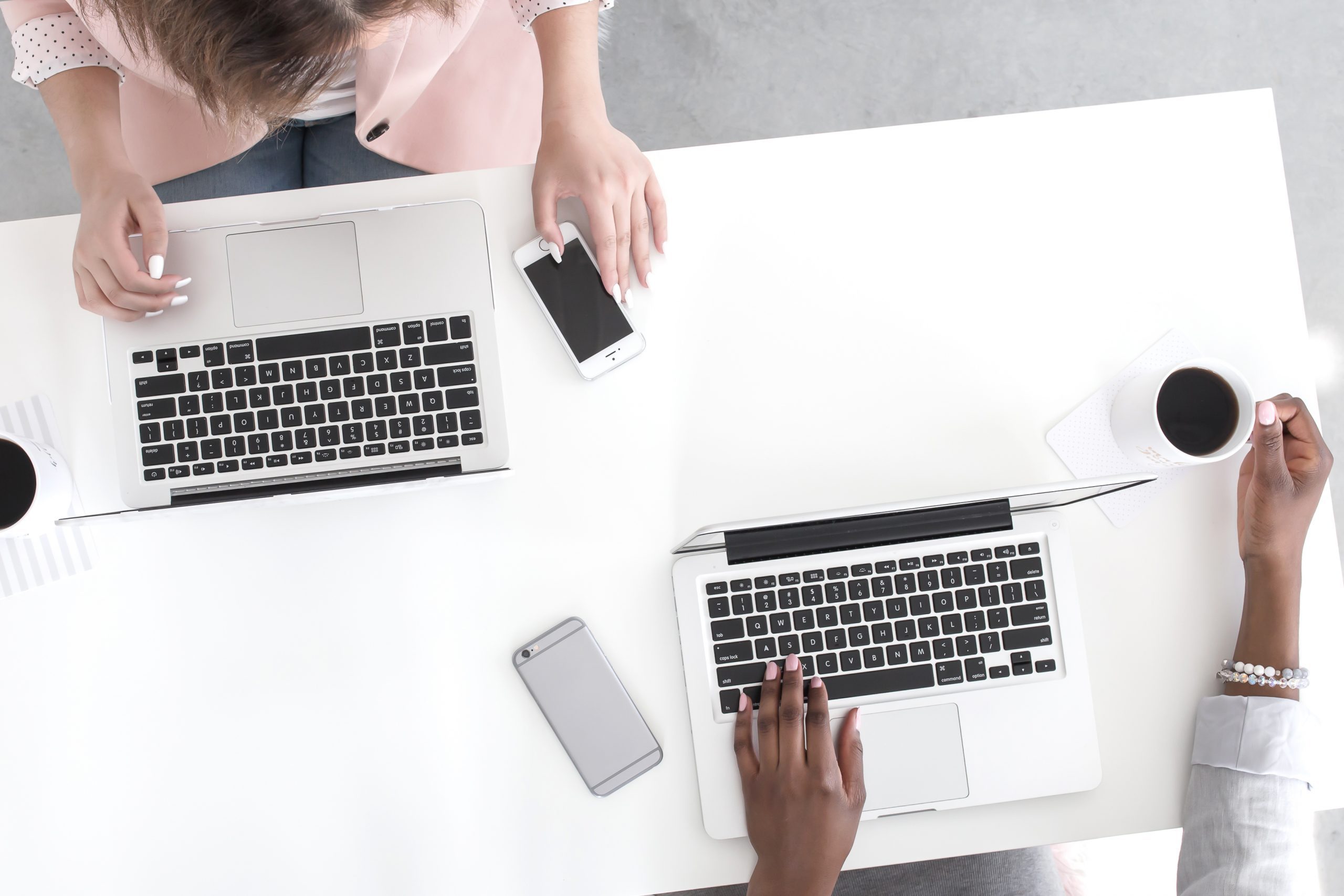 Overhead of two women working opposite each other on laptops