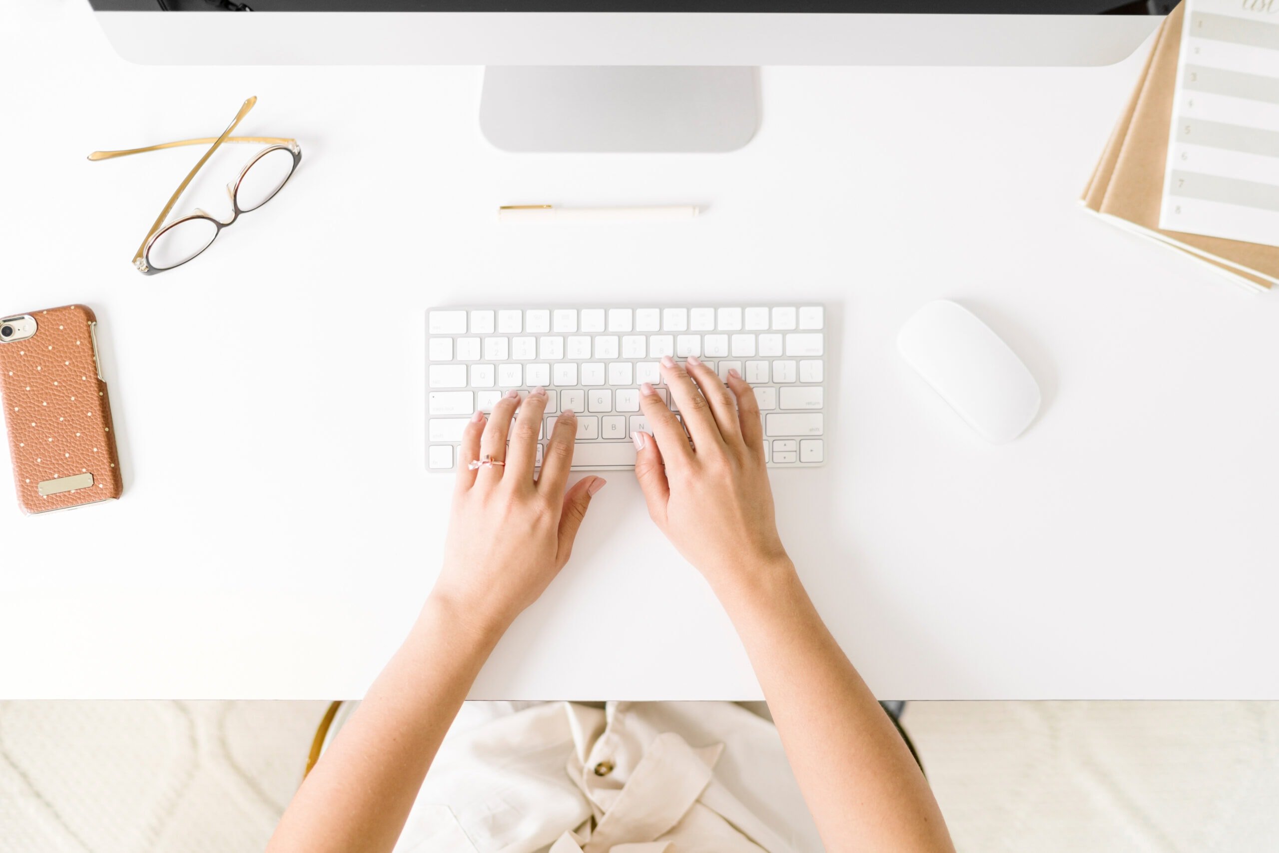 Woman typing on a white keyboard