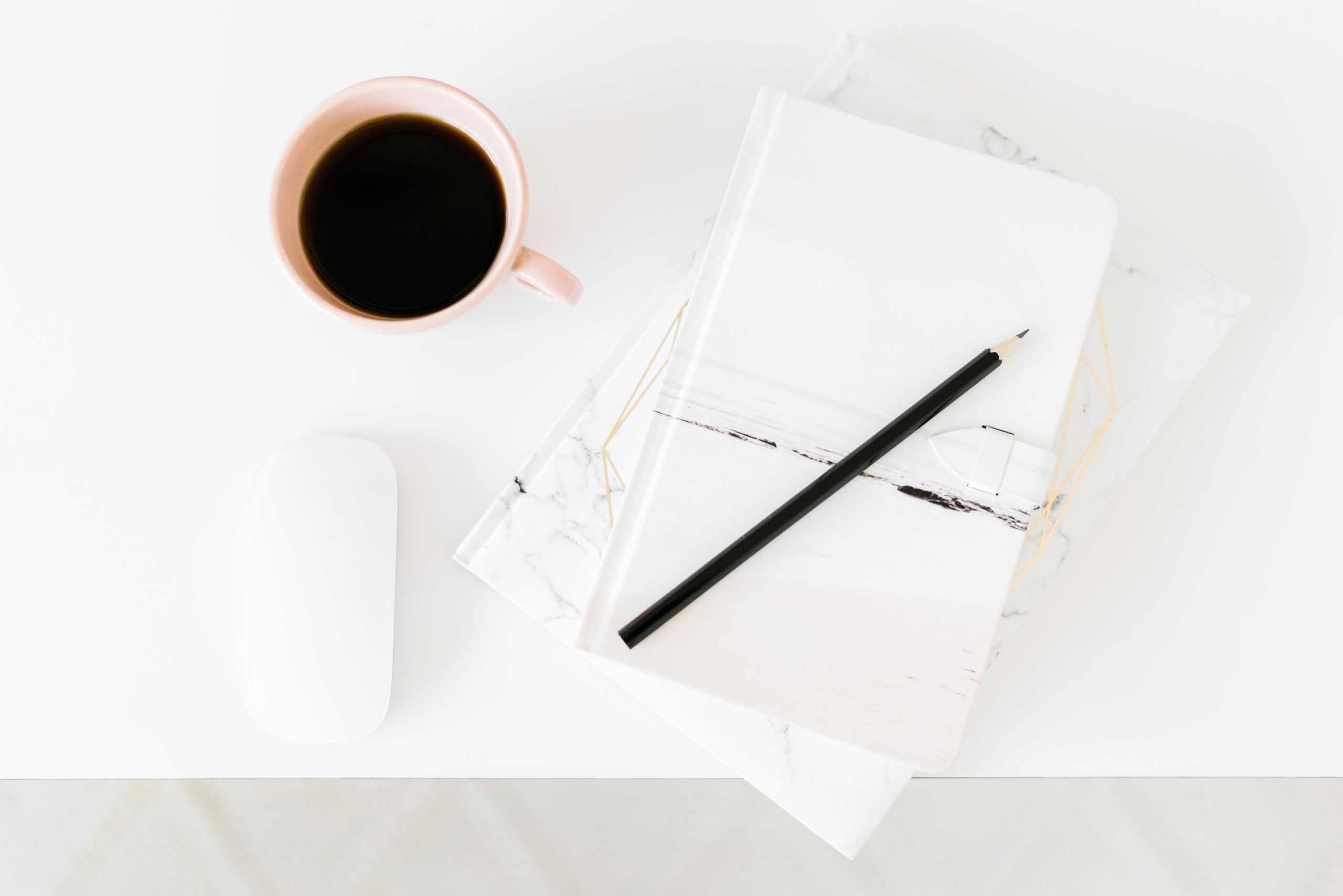 Overhead of notepad, pencil and coffee mug