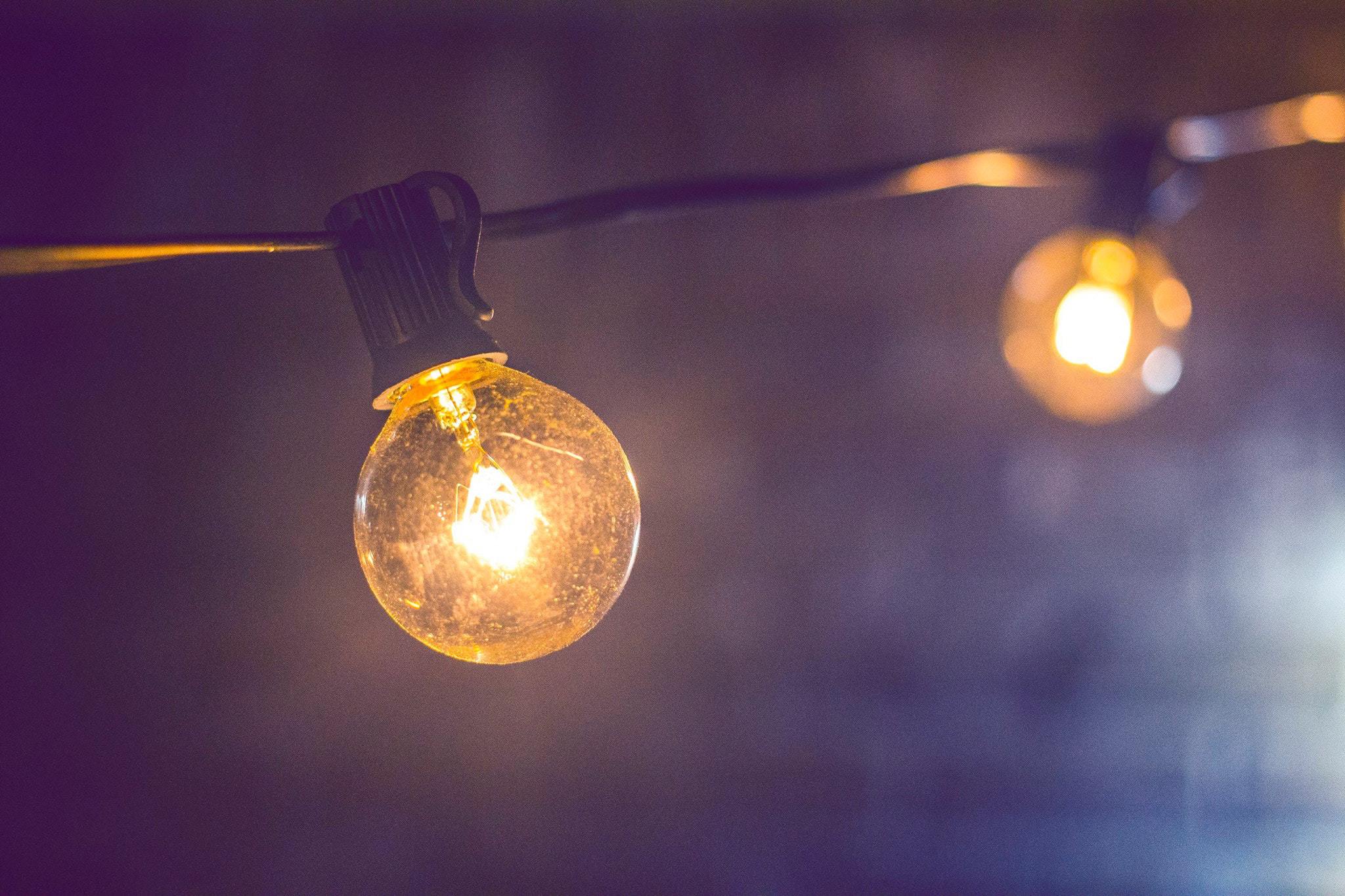 Two bare lightbulbs glowing in the dark