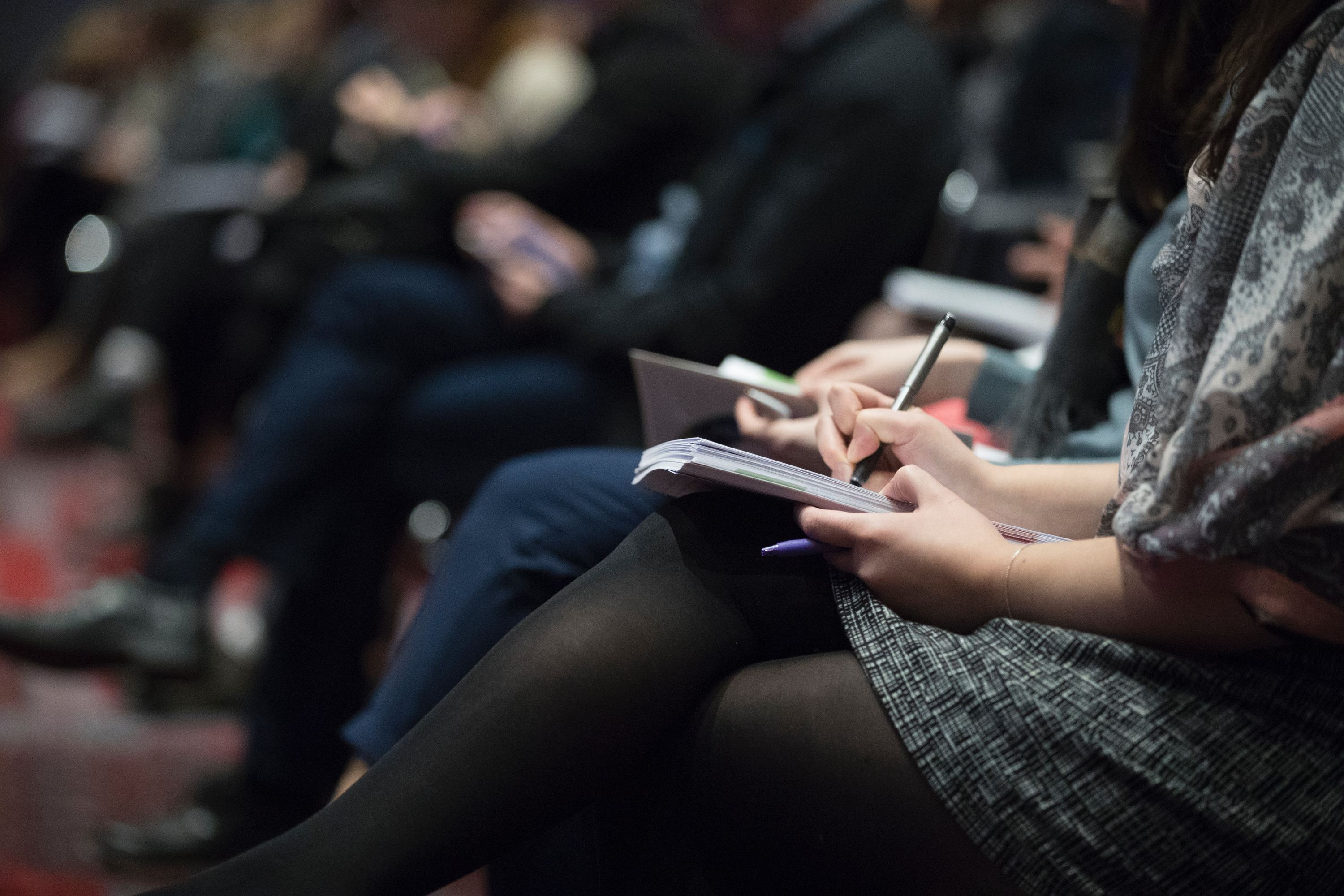 Woman taking notes at a conference